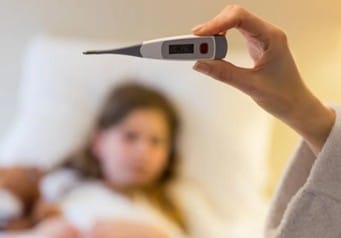 Picture1 | roma hospital Person in bed holding a digital thermometer toward the camera, suggesting a fever or illness in the background